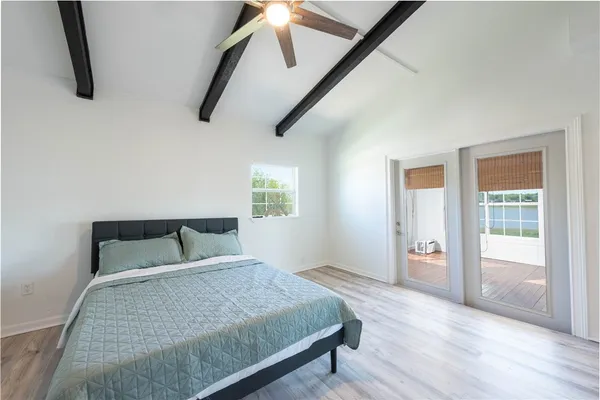 a bedroom with a bed and wooden floor