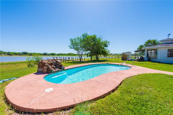 a view of a house with swimming pool and yard