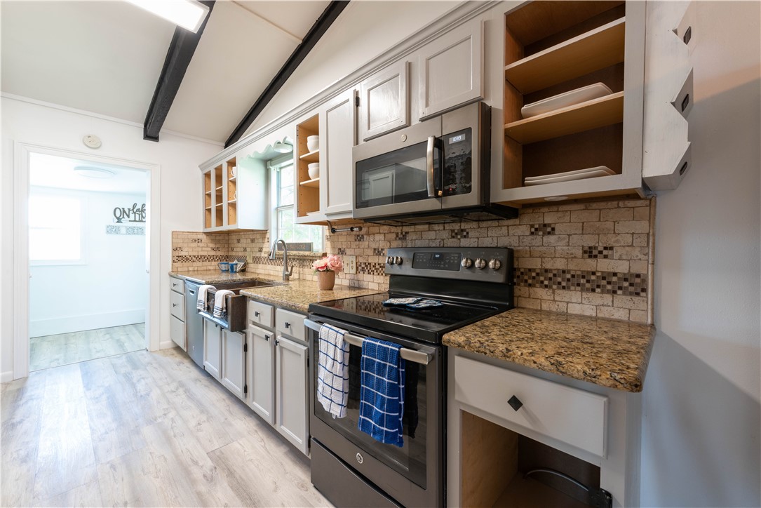 132 Zenna Drive Mathis, TX 78368 - Photo 5 of 40 a kitchen with stainless steel appliances granite countertop a stove and a microwave