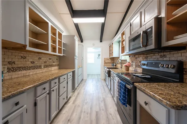 a kitchen with stainless steel appliances granite countertop a stove and a sink