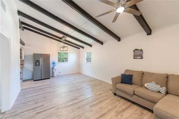 a living room with furniture and a ceiling fan
