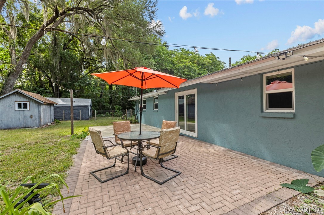 107 Allen Avenue Inglis, FL 34449 - Photo 23 of 36 a patio with a table and chairs under an umbrella