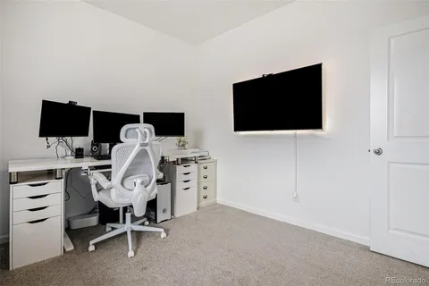 a view of a livingroom with a flat screen tv and a workspace