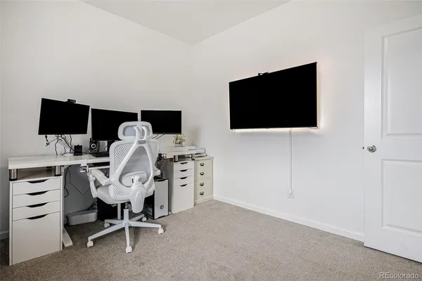 a view of a livingroom with a flat screen tv and a workspace