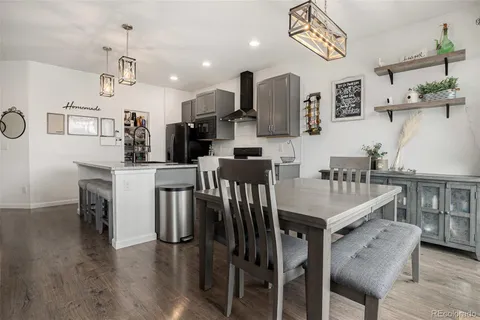 a kitchen with stainless steel appliances a table chairs and a refrigerator