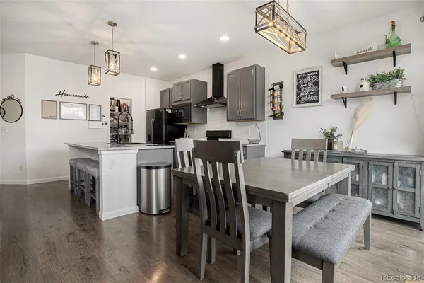 a kitchen with stainless steel appliances a table chairs and a refrigerator