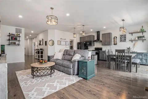 a living room with lots of furniture and kitchen view