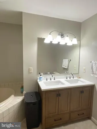 a living room with furniture a flat screen tv and a refrigerator