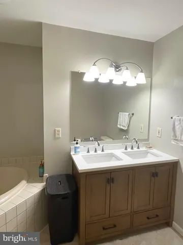 a living room with furniture a flat screen tv and a refrigerator