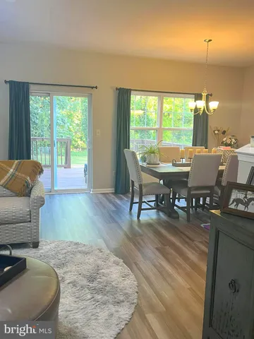 a view of a dining room with furniture a chandelier and wooden floor
