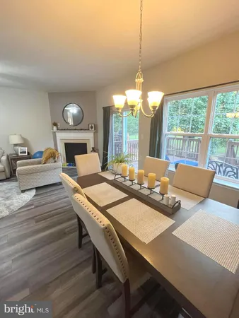 a large kitchen with stainless steel appliances granite countertop a stove top oven a sink dishwasher a dining table and chairs with wooden floor