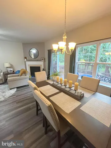 a large kitchen with stainless steel appliances granite countertop a stove top oven a sink dishwasher a dining table and chairs with wooden floor