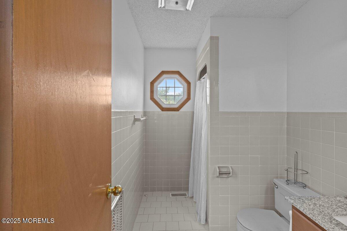 100 3rd Avenue Lavallette, NJ 08735 - Photo 25 of 39 a bathroom with a granite countertop toilet and a shower