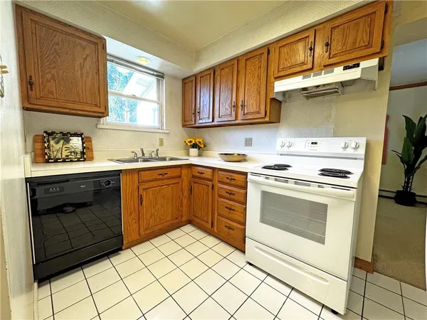 a kitchen with a stove sink and cabinets