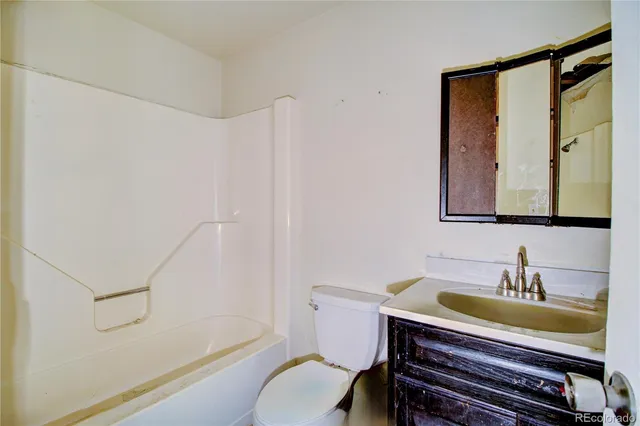 a bathroom with a granite countertop sink a toilet and a bathtub