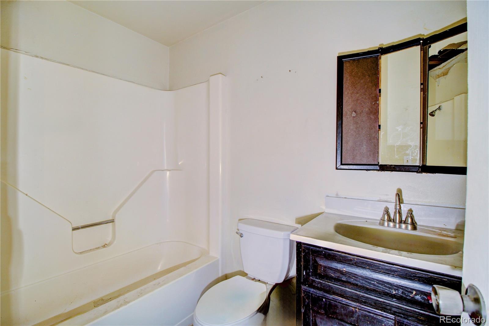 9340 West 49th Avenue, Unit 213 Wheat Ridge, CO 80033 - Photo 12 of 16 a bathroom with a granite countertop sink a toilet and a bathtub