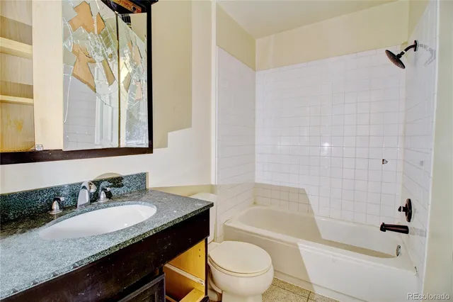 a bathroom with a granite countertop sink toilet a mirror and shower