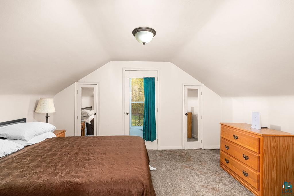 4543 County Road East South Range, WI 54874 - Photo 18 of 43 Attic room featuring sloped ceilings, a central ceiling light fixture, and carpet flooring