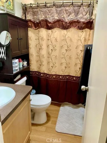a bathroom with a granite countertop toilet and a sink
