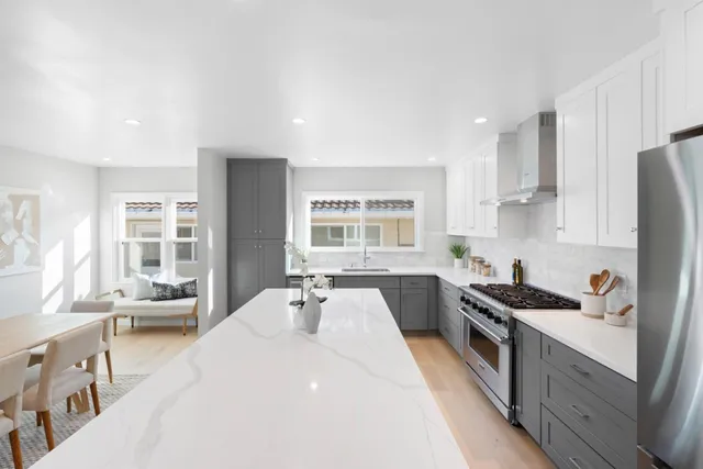 a kitchen with stainless steel appliances a stove a sink a refrigerator and cabinets