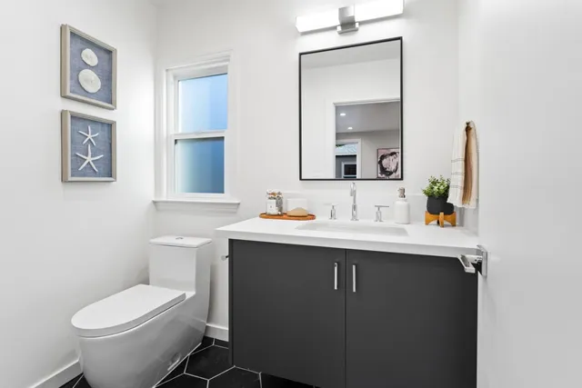 a bathroom with a toilet sink and mirror