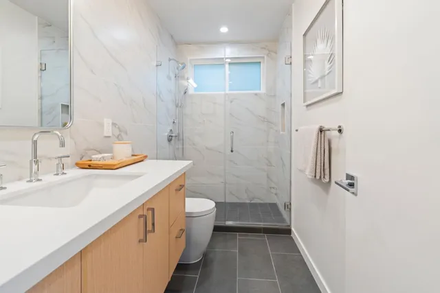 a bathroom with a sink a toilet and shower