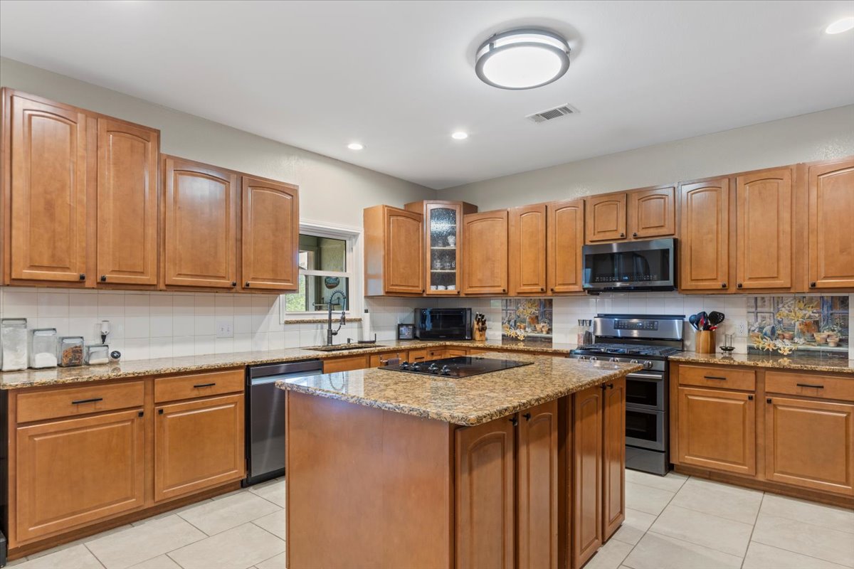 550 League Line Road Smithville, TX 78957 - Photo 13 of 40 a kitchen with stainless steel appliances granite countertop a stove sink microwave and cabinets
