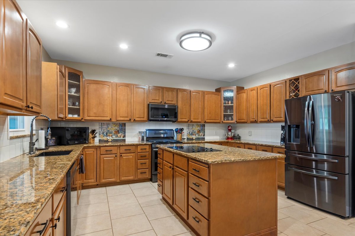 550 League Line Road Smithville, TX 78957 - Photo 14 of 40 a kitchen with stainless steel appliances granite countertop a stove top oven a refrigerator a sink and dishwasher
