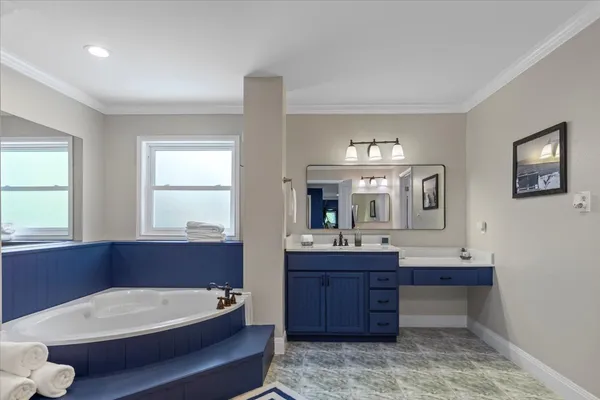 a bathroom with a tub sink and mirror