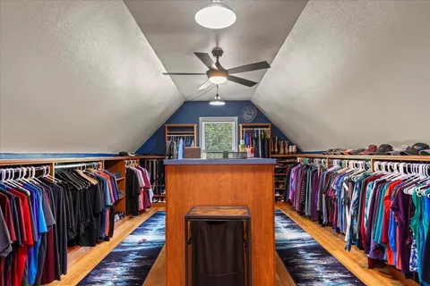 a view of walk in closet with clothes and shoes