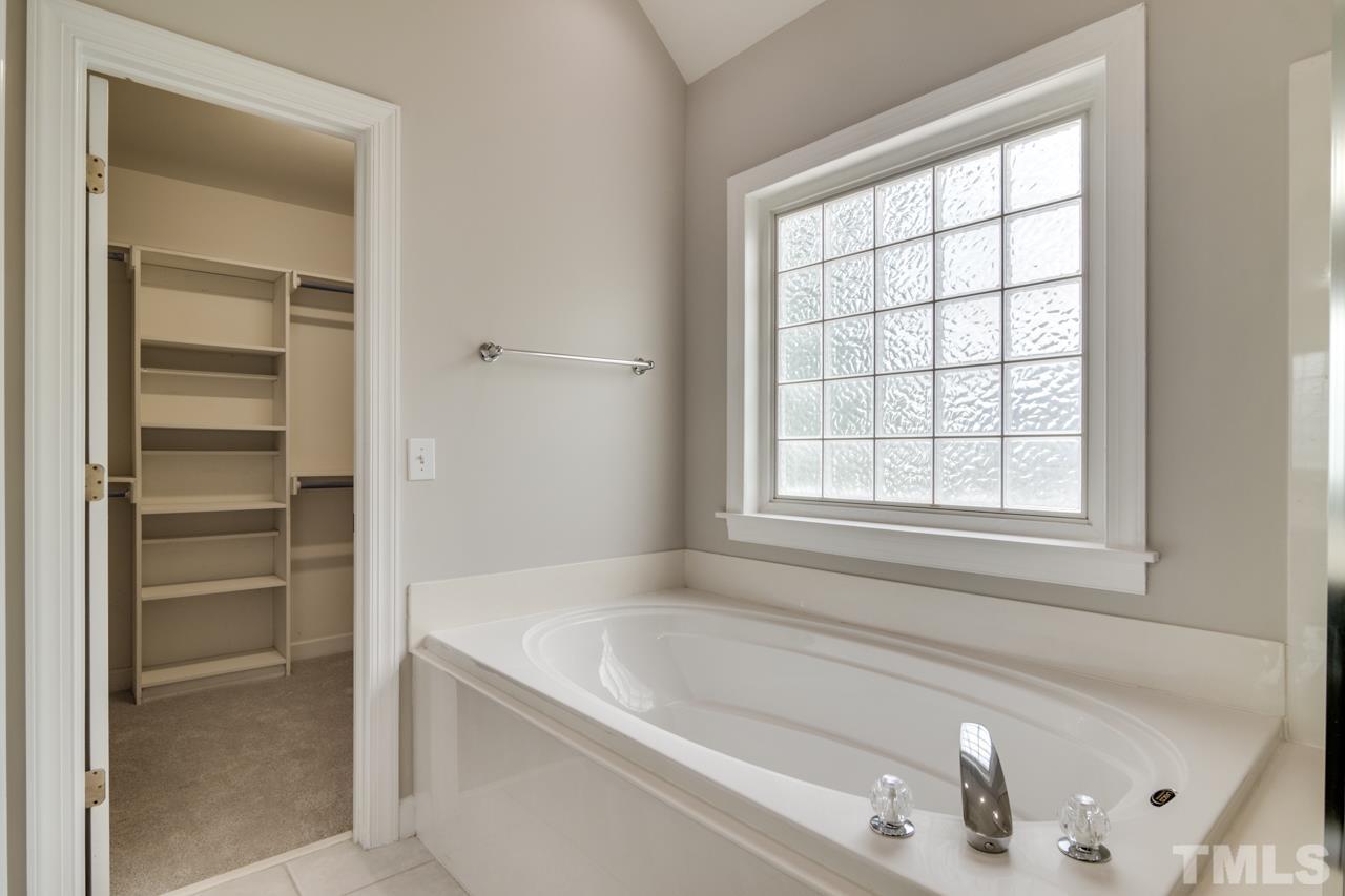 8208 Manatee Court Raleigh, NC 27616 - Photo 22 of 30 a bathroom with bathtub and window