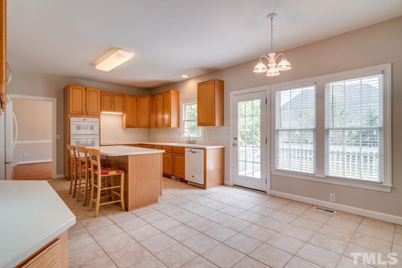 8208 Manatee Court Raleigh, NC 27616 - Photo 8 of 30 a large kitchen with kitchen island granite countertop a stove a sink a dining table and chairs