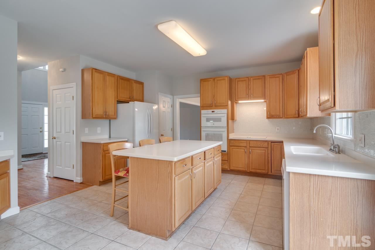 8208 Manatee Court Raleigh, NC 27616 - Photo 9 of 30 a kitchen that has a sink and a stove in it