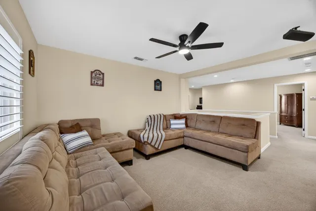a spacious bedroom with a bed and a ceiling fan