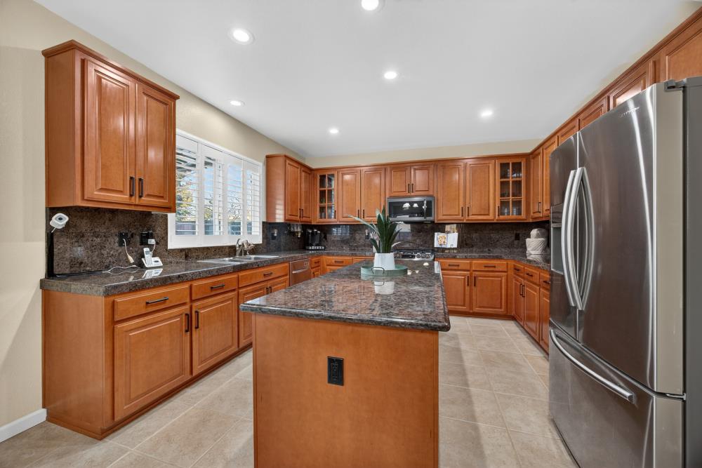 3670 Topaz Road West Sacramento, CA 95691 - Photo 73 of 97 a kitchen with stainless steel appliances granite countertop a refrigerator a sink a stove a washer and dryer with wooden cabinets