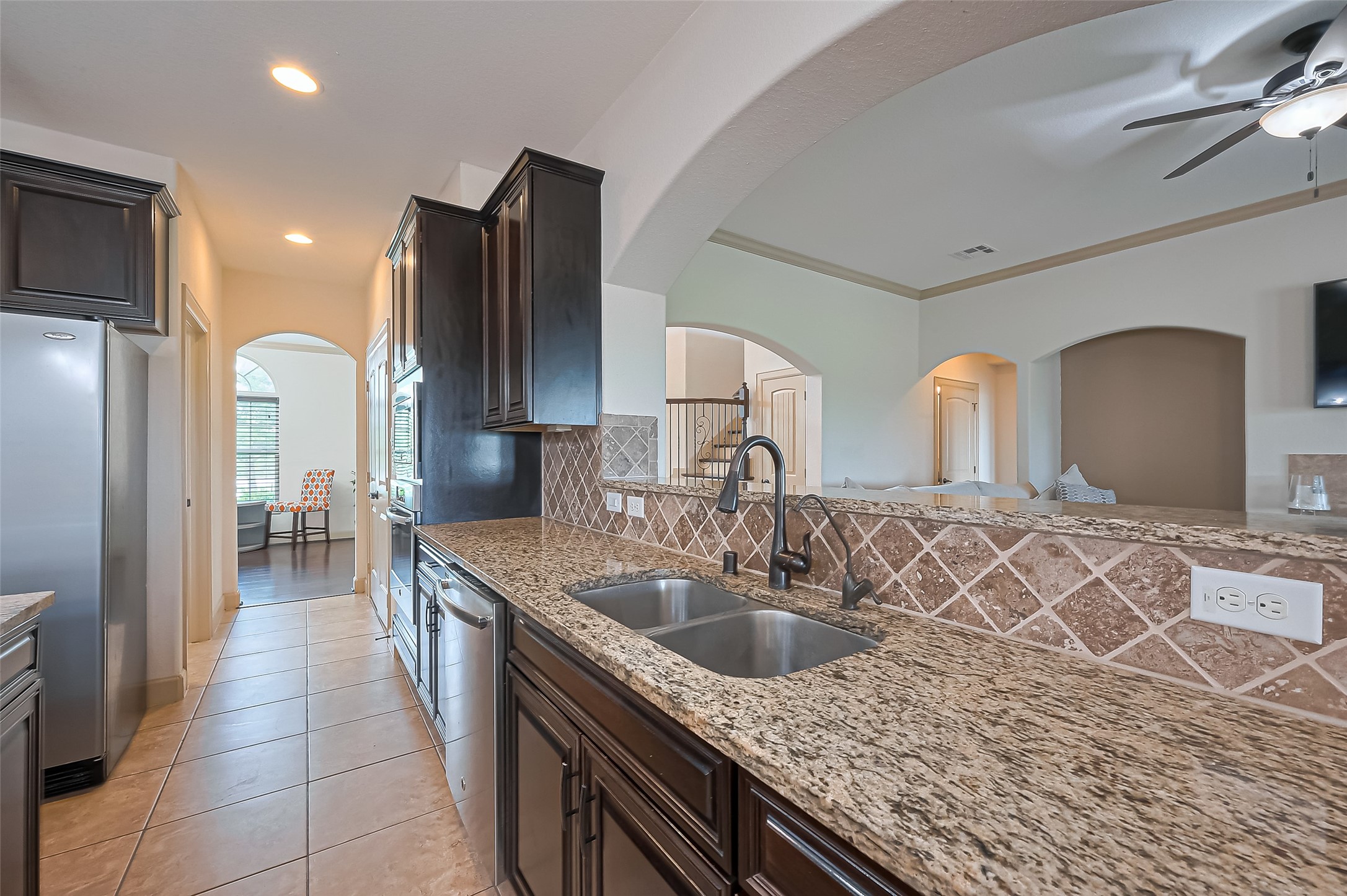 4810 Dubuque Parkway Rosharon, TX 77583 - Photo 17 of 45 a kitchen with stainless steel appliances granite countertop a sink dishwasher a refrigerator and a wooden cabinets