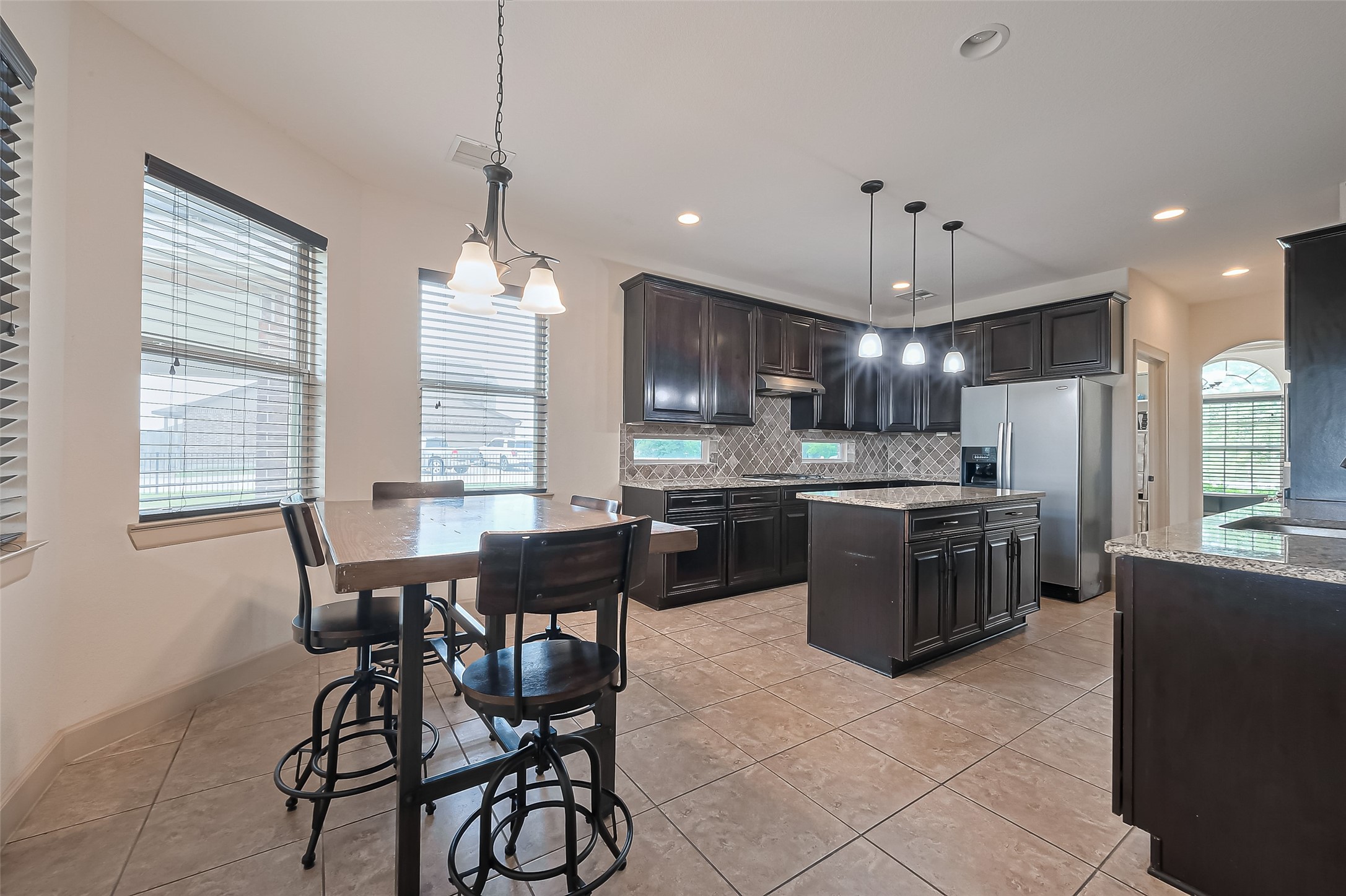 4810 Dubuque Parkway Rosharon, TX 77583 - Photo 3 of 45 a kitchen with stainless steel appliances granite countertop a stove a refrigerator a sink dishwasher a dining table and chairs with wooden floor