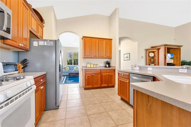 a kitchen with stainless steel appliances granite countertop a stove a sink and a refrigerator