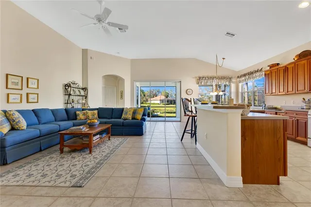 a living room with couches and kitchen view