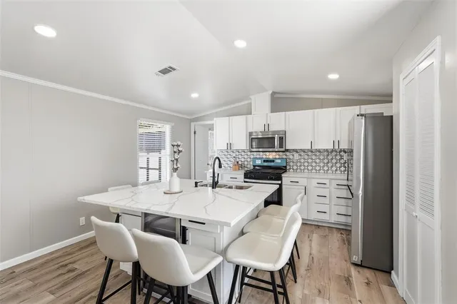 a kitchen with a dining table chairs refrigerator and cabinets