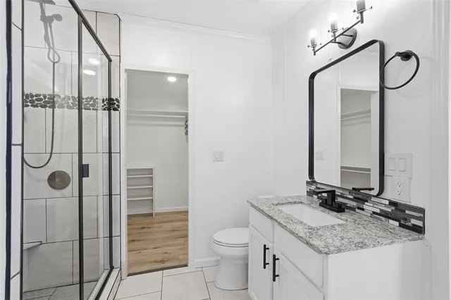 a bathroom with a granite countertop sink toilet and shower
