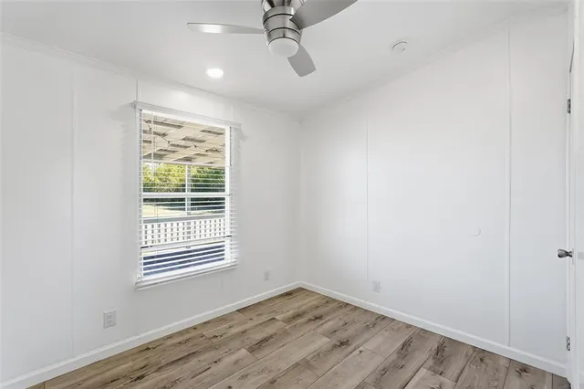 an empty room with a window and wooden floor