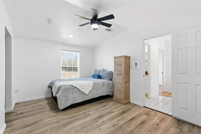 a spacious bedroom with a bed and a ceiling fan