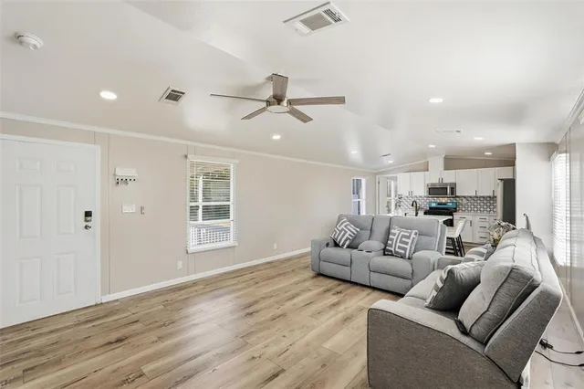 a living room with furniture and a ceiling fan