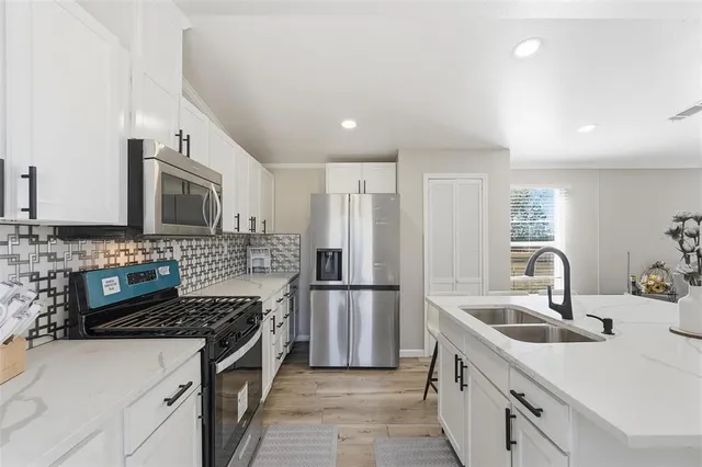 a kitchen with stainless steel appliances granite countertop a sink stove and refrigerator