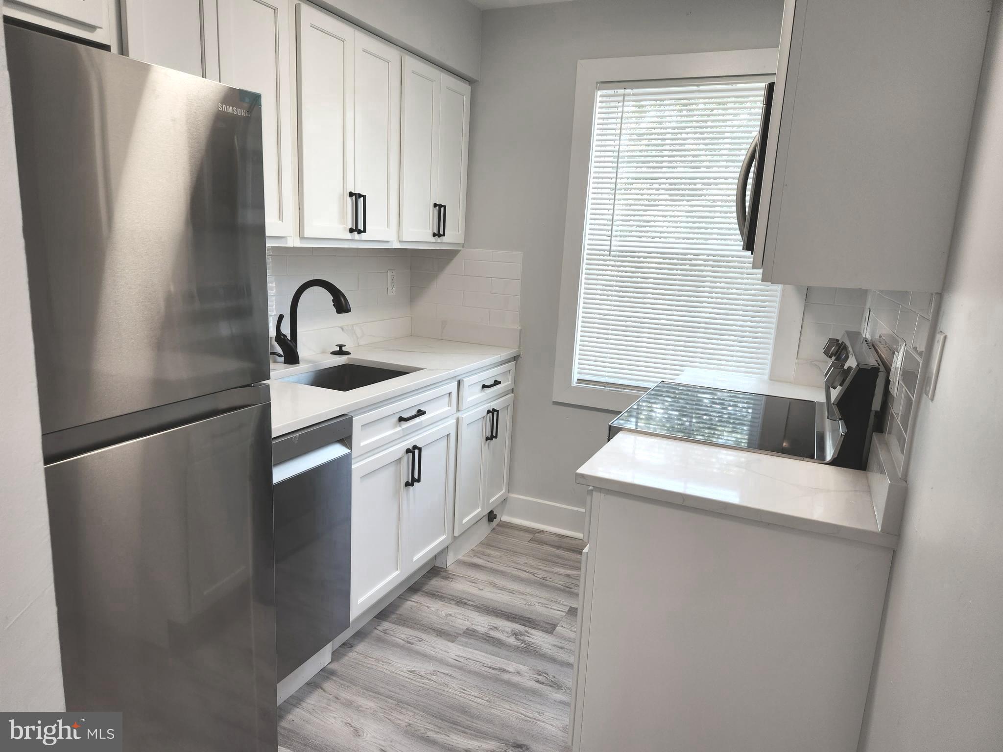 a kitchen with stainless steel appliances granite countertop a refrigerator sink and stove