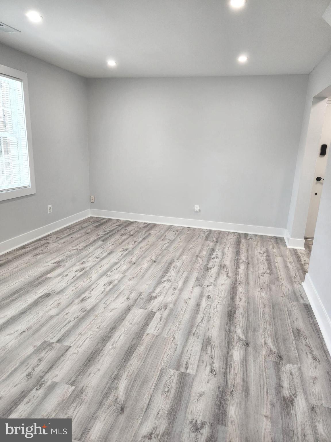 3809 V Street Southeast, Unit 202 Washington, DC 20020 - Photo 11 of 20 an empty room with wooden floor and windows