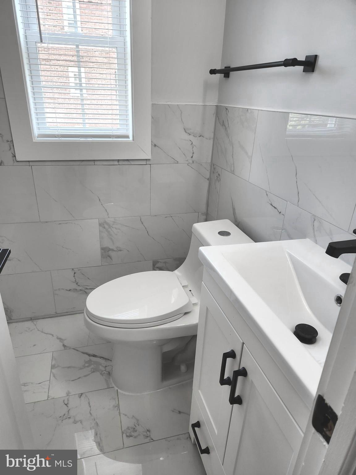 3809 V Street Southeast, Unit 202 Washington, DC 20020 - Photo 16 of 20 a white toilet sitting next to a bathroom sink