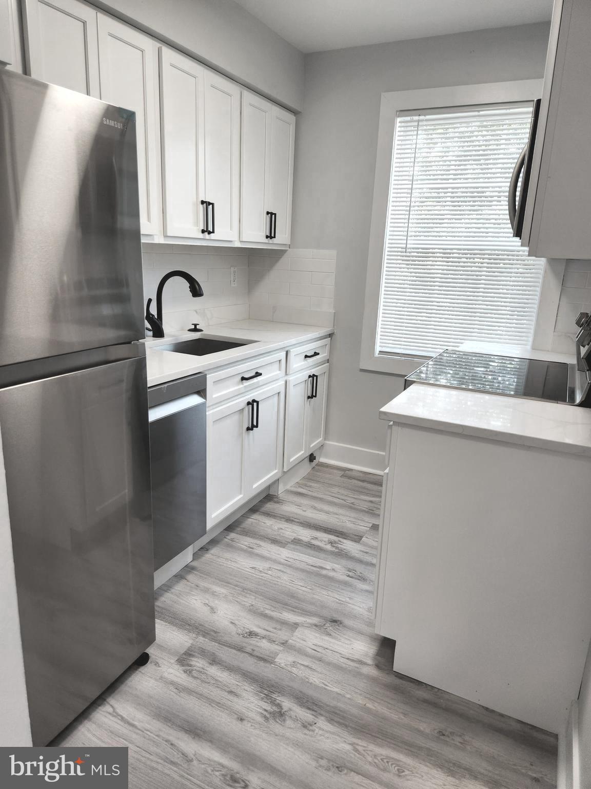 3809 V Street Southeast, Unit 202 Washington, DC 20020 - Photo 2 of 20 a kitchen with stainless steel appliances granite countertop a sink stove and refrigerator