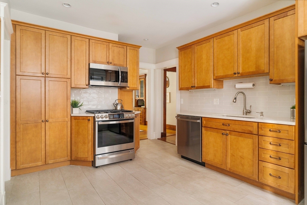 59 Pemberton Street, Unit 1 Cambridge, MA 02140 - Photo 11 of 30 a kitchen with stainless steel appliances granite countertop a stove a sink and a microwave